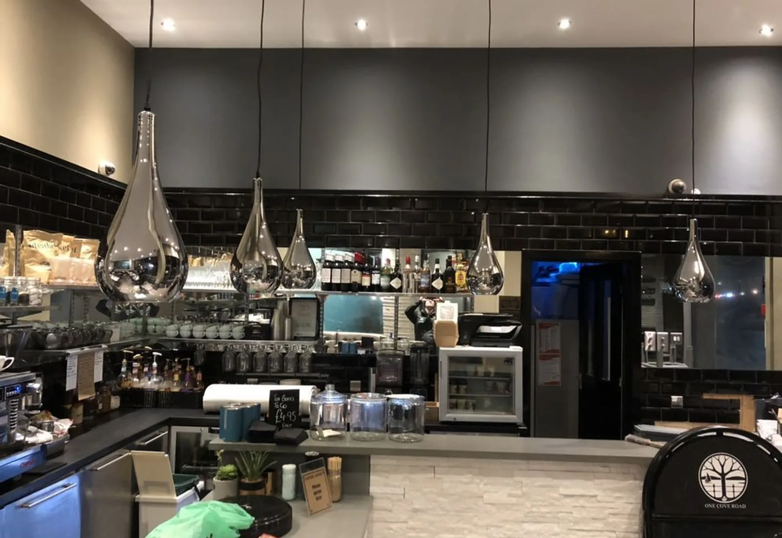 Teardrop pendant lights and spotlights over a cafe counter, a commercial lighting fit-out