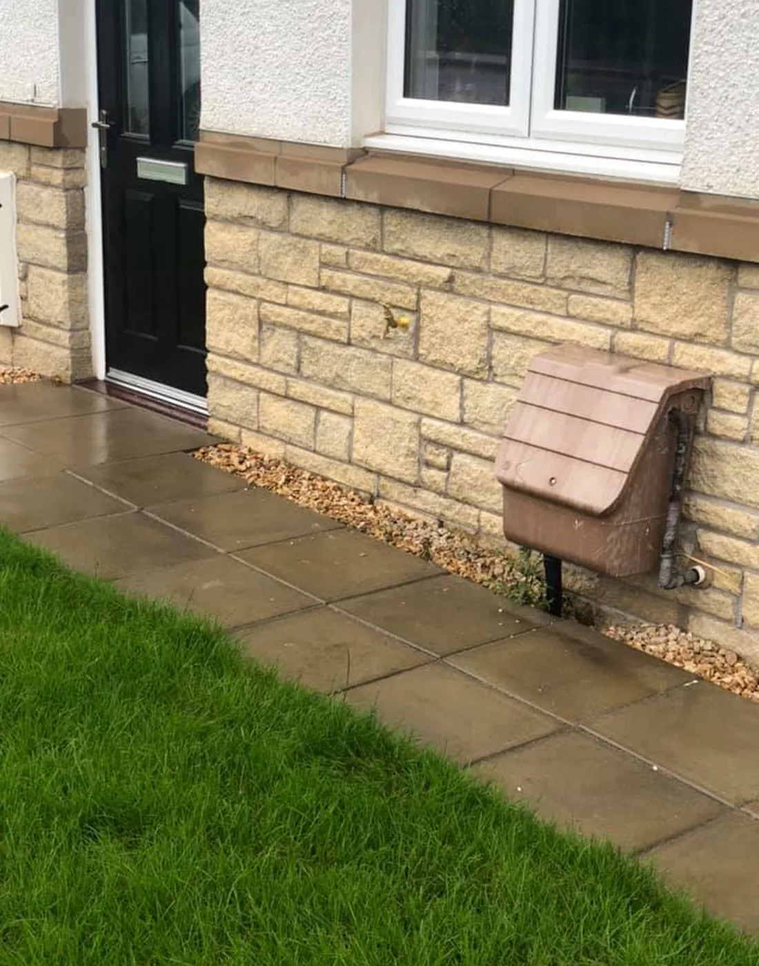 An outside tap in an insulated cover at a new-build front door